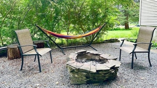 Un espace extérieur aménagé avec un foyer et deux chaises.