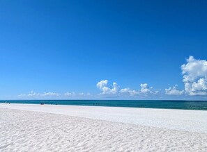 A wide sandy beach with a clear blue sky and calm sea. - Amazing updated 2/2 Nokomis home with heated pool! (Nokomis)