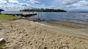 A sandy beach with a dock extending into a calm body of water. - Rainy Dream Vacation - Spacious accomodations, large yard, incredible view!

 (International Falls)