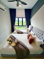 A bedroom with a bed, a ceiling fan, a window with curtains, and an air conditioning unit.