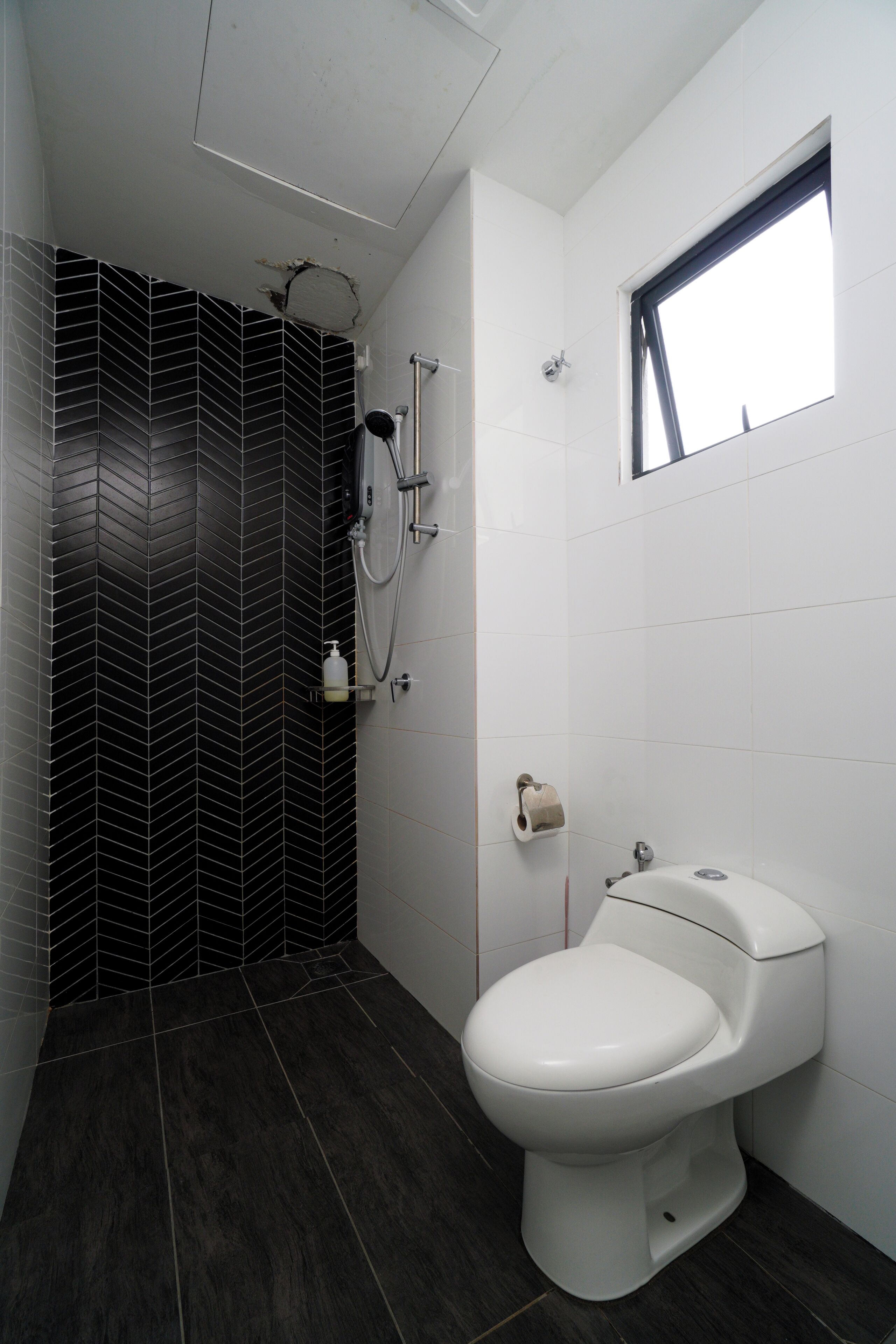 Un bagno moderno con pavimento a scacchi in bianco e nero, un water bianco, un angolo doccia e una piccola finestra.