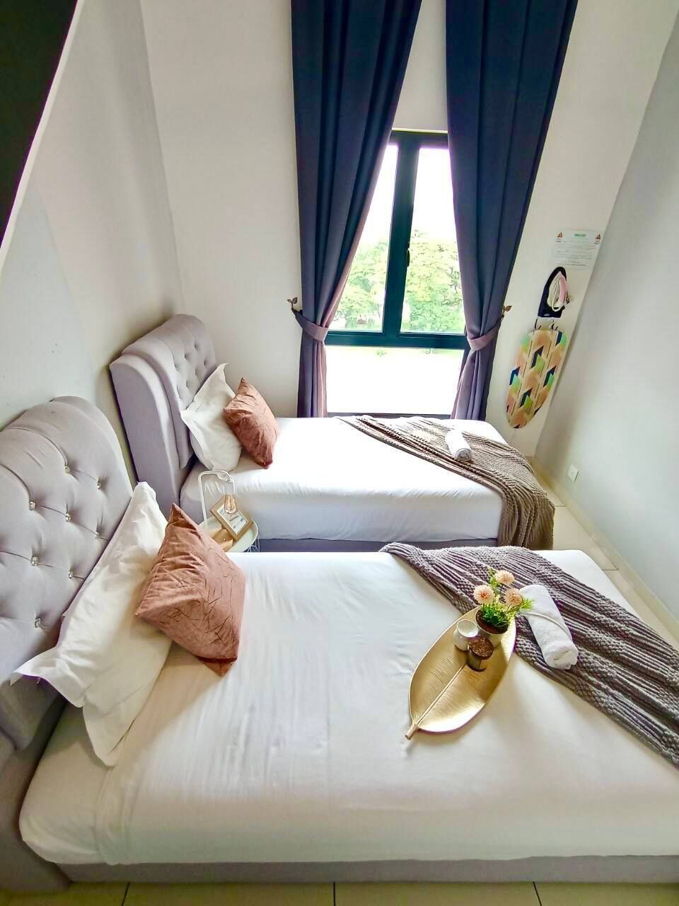 Ein Schlafzimmer mit zwei Betten, einem fensterbelaubten Fenster, einer Wanduhr und einer kleinen Pflanze auf dem Nachttisch.