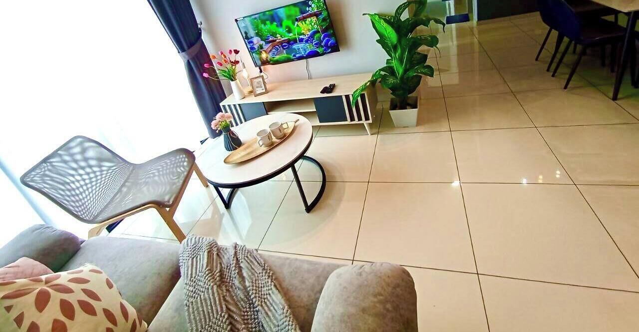 A living room with a TV, a dining table, chairs, a sofa, and a coffee table.