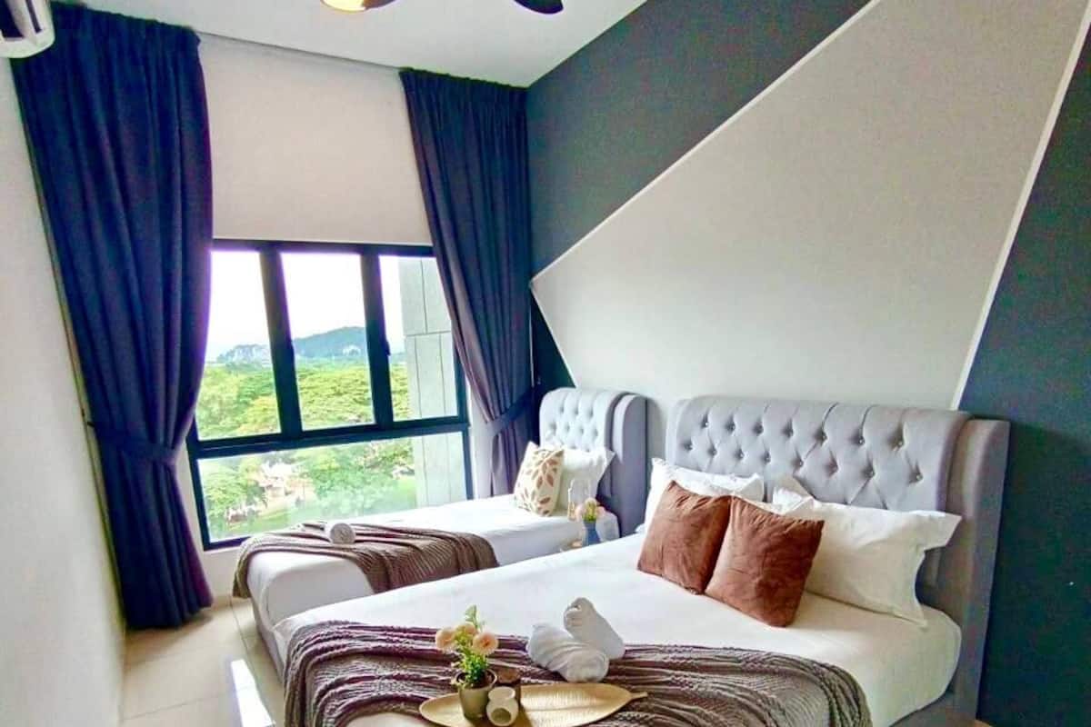 A modern bedroom with a large bed, a ceiling fan, and a view of greenery outside.