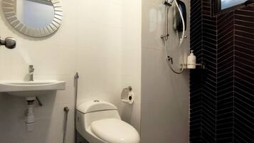A bathroom with a toilet, sink, and shower.
