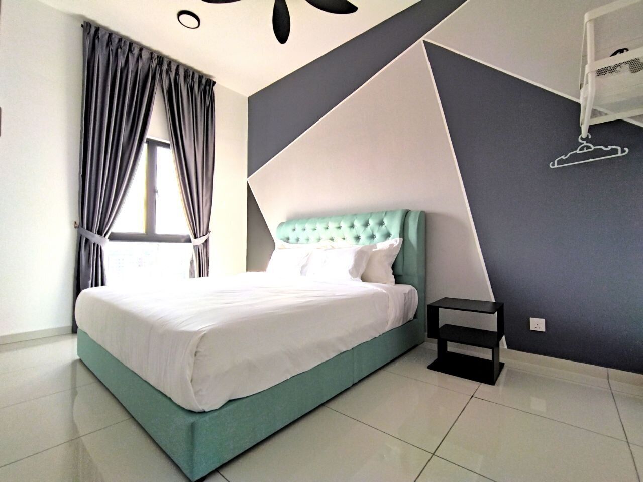 Un dormitorio moderno con una cama, una mesita de noche y un ventanal con cortinas.