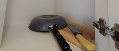 A kitchen corner with a frying pan and a spatula on the counter.