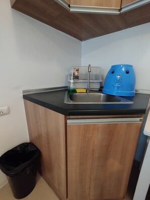 A compact kitchen with a sink, a Megabox soap dispenser, and a blue kettle. - Cebu Avida Riala T1 1517 IT Park (Cebu City)