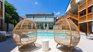 A poolside area with wicker chairs and a white bollard. - Modern Urban Oasis in Prime Buckhead, Atlanta (Atlanta)