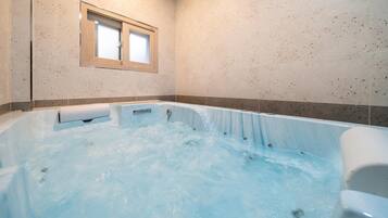 Relax in a spacious bathtub surrounded by speckled tiles and natural light.