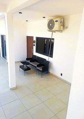 Una habitación con sofá, una mesita de centro y aire acondicionado instalado en la pared.