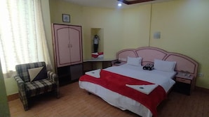 Een slaapkamer met een bed, een stoel, een kledingkast en een nachtkastje.