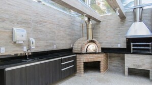 Una cocina con horno de ladrillo, muebles de cocina modernos y tragaluces.
