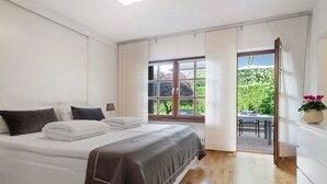 Un dormitorio con una cama, una ventana y vistas al exterior.