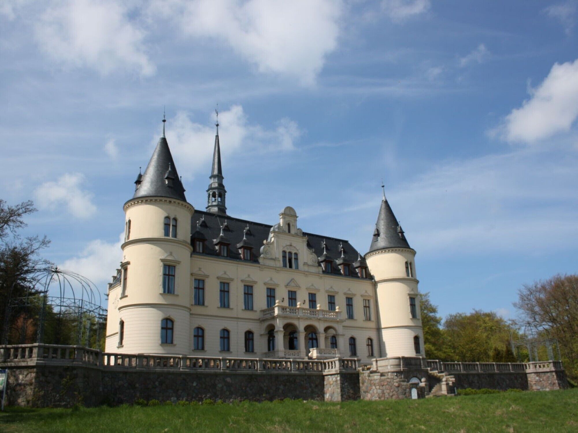 A large, historic building with multiple towers and a prominent central spire.
