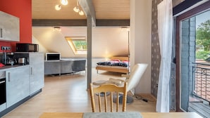 Cozinha moderna com área de jantar, uma cadeira de madeira e uma cama com vista.