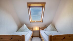 A small, single-room accommodation with two wooden bunk beds, a skylight, and a bedside table with a lamp. - Apartment Morgensonne, 55 sqm, 2 bedrooms, max. 4 persons (Hofstetten)