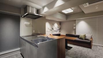 A modern kitchen with a central island, built-in appliances, and a dining area with a sofa and table.