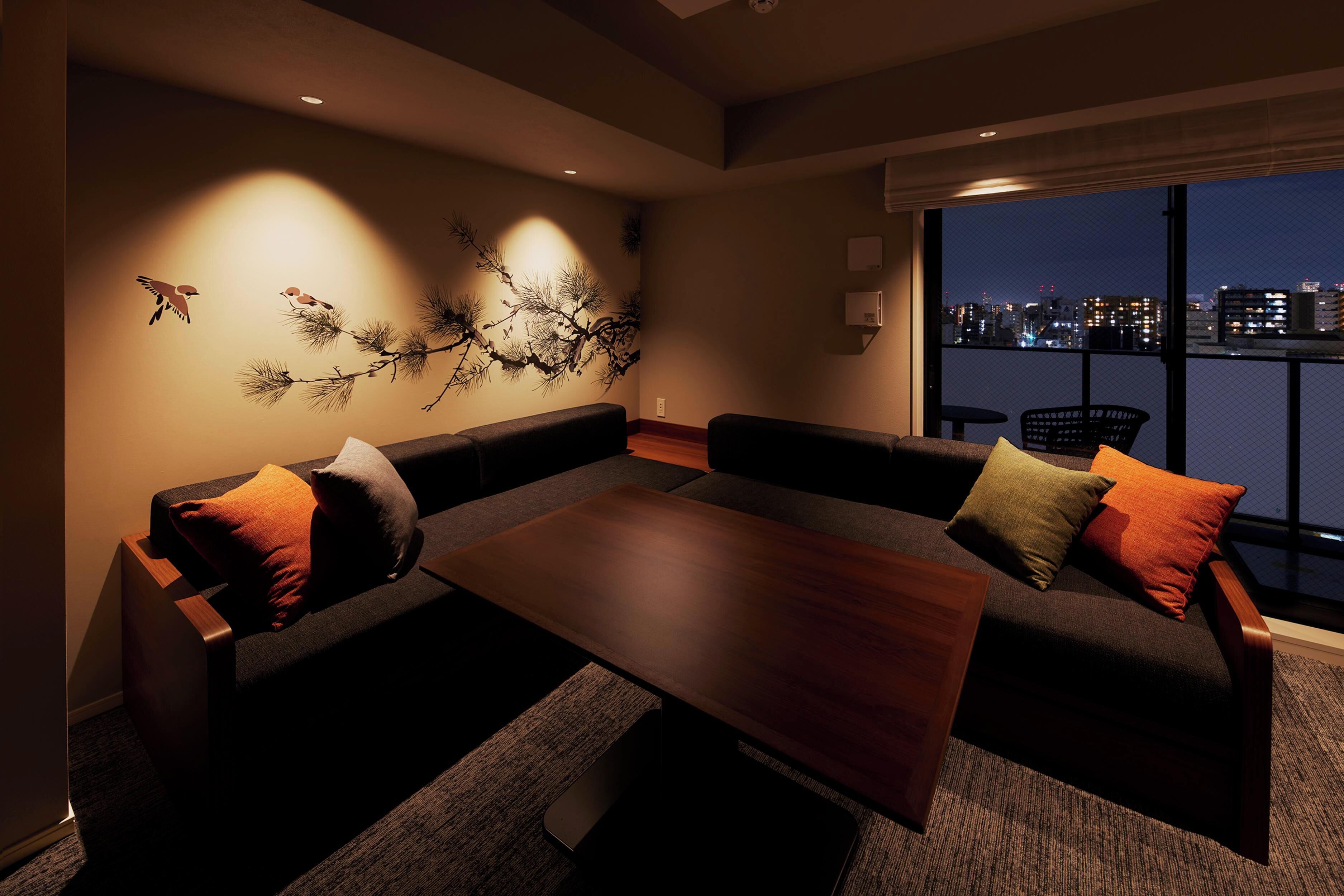 A modern living room with a sofa set, a coffee table, and a wall art piece.