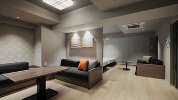 Una habitación de hotel moderna con sofá, una mesita, una cama y un baño visible a través de una puerta abierta.