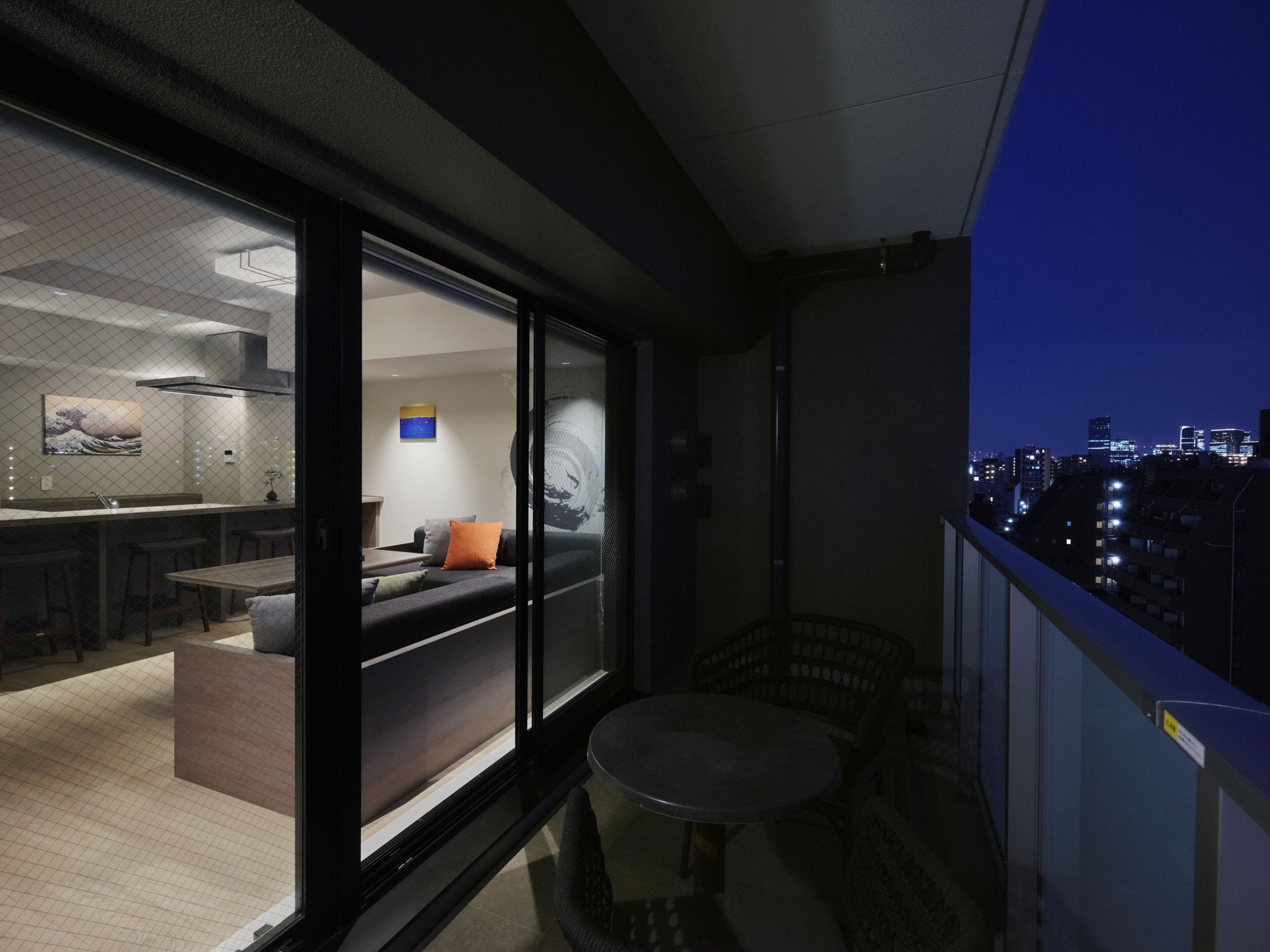 Un espace de vie moderne comprenant une cuisine, un coin repas et un balcon offrant une vue sur la ville.