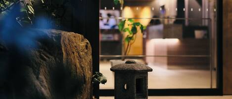 A stone lantern and a large rock planter in a modern indoor setting.