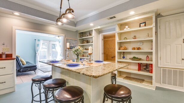 A kitchen with a central island, bar stools, and a built-in pantry. - Pet-Friendly Fort Walton Beach Home: 4 Mi to Ocean (Fort Walton Beach)