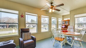 A room with a ceiling fan, a dining table with chairs, a leather sofa, and a window with a star decoration. - Pet-Friendly Fort Walton Beach Home: 4 Mi to Ocean (Fort Walton Beach)