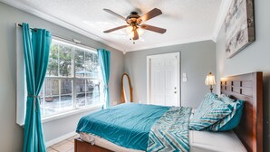 A bedroom with a bed, a ceiling fan, a window with curtains, and a door. - Pet-Friendly Fort Walton Beach Home: 4 Mi to Ocean (Fort Walton Beach)