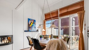 Ein Essbereich mit Holztisch, Stühlen und einer hängenden Leuchte.