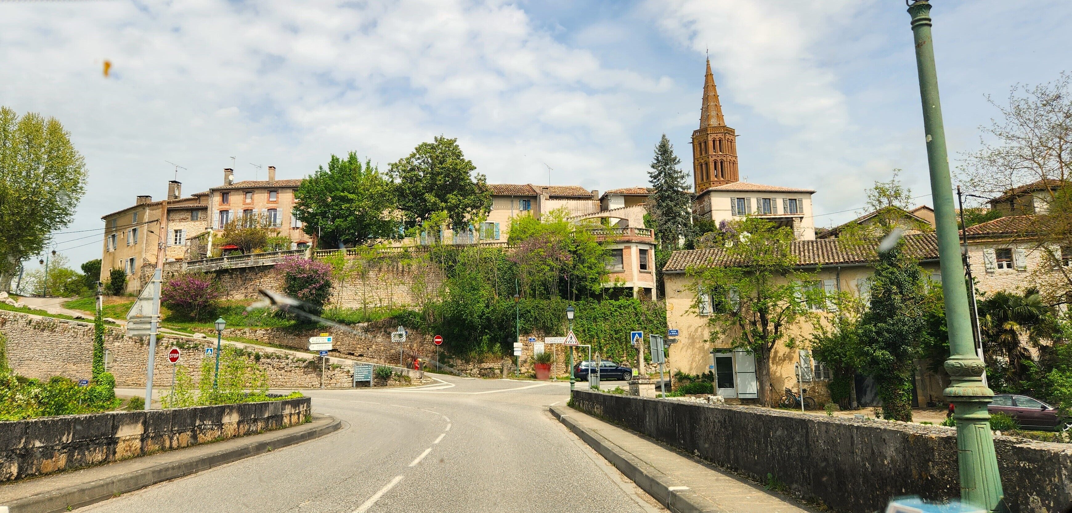 A street with buildings, a church tower, and a stop sign.