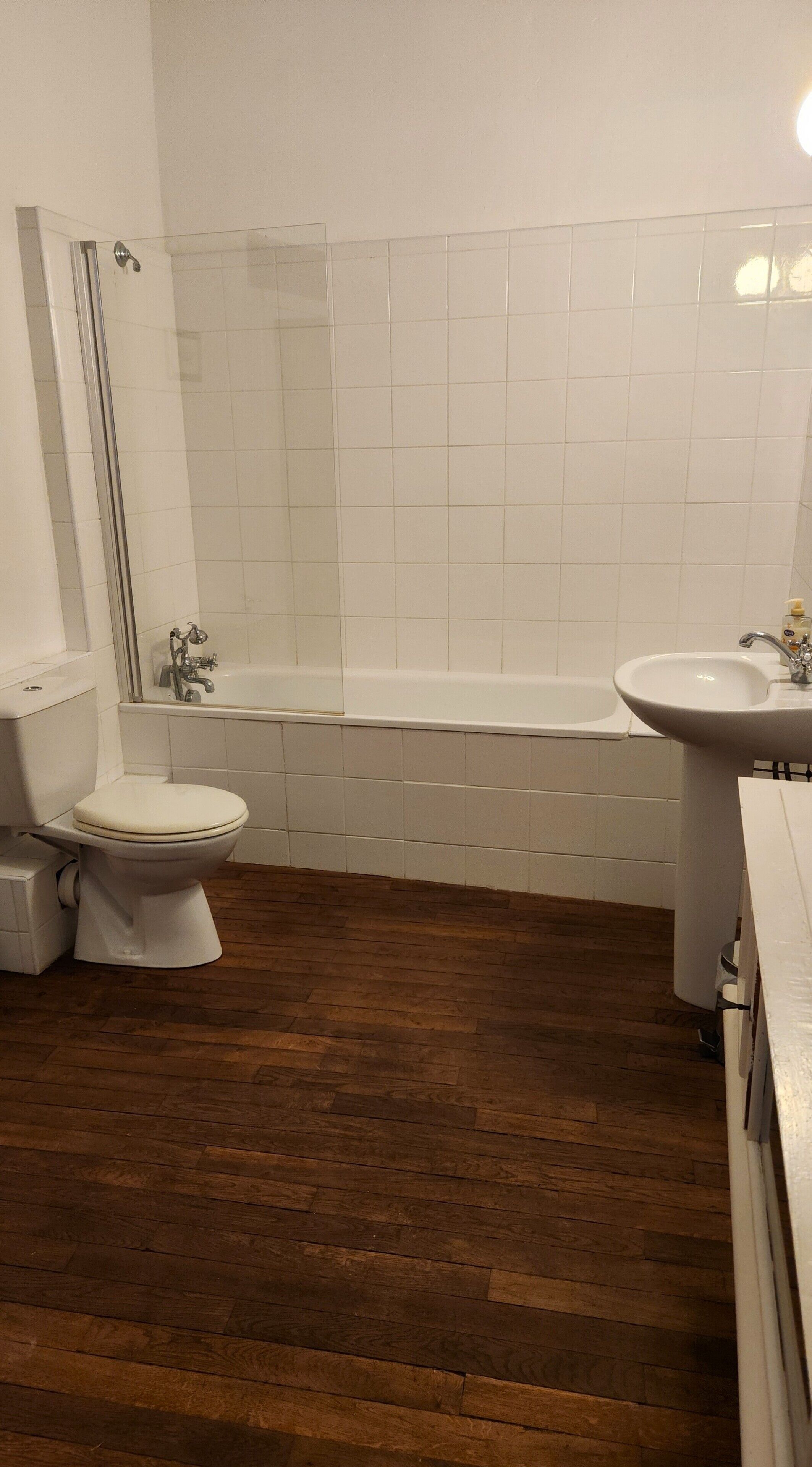 A bathroom with a toilet, a bathtub, and a sink.