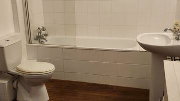 A bathroom with a toilet, a bathtub, and a sink.