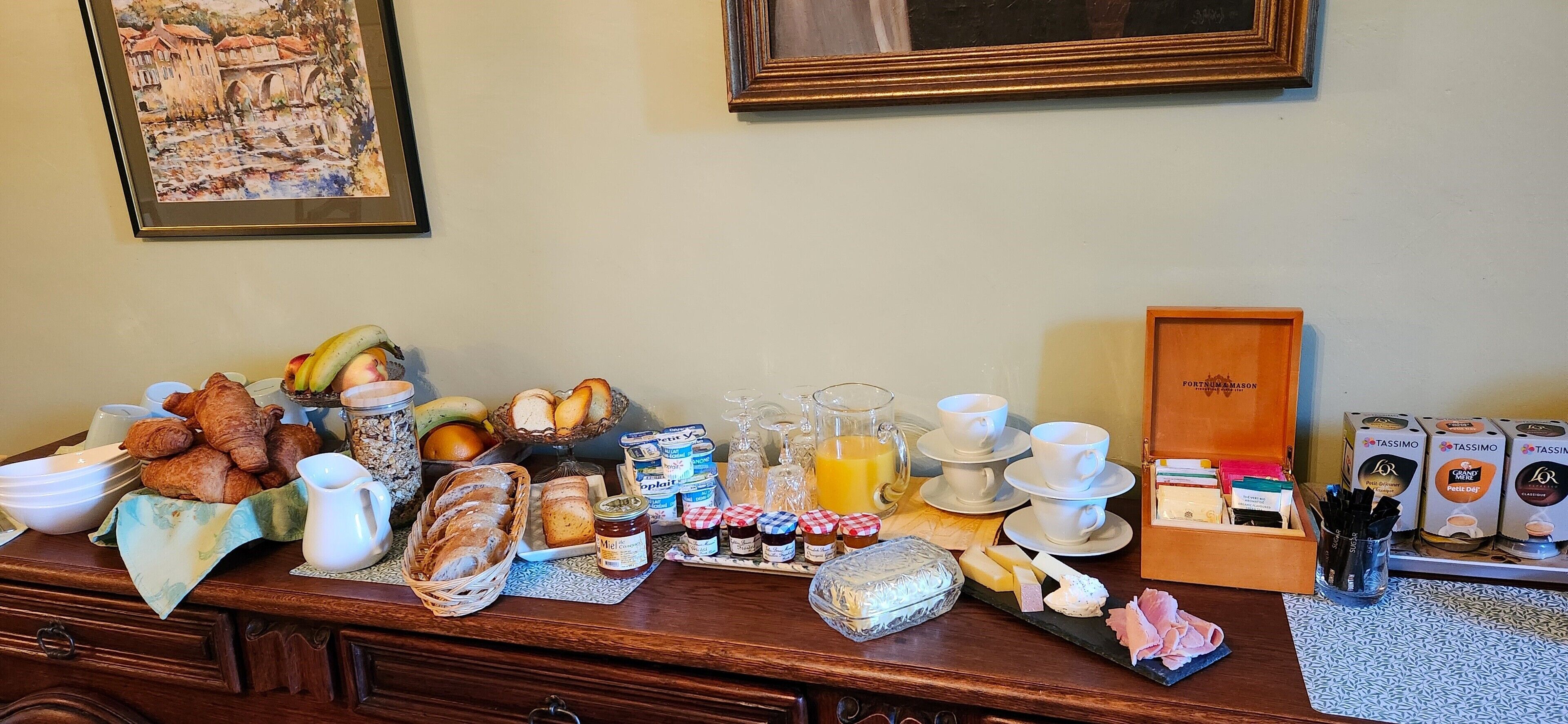A breakfast buffet with various food items, including pastries, fruits, and beverages.