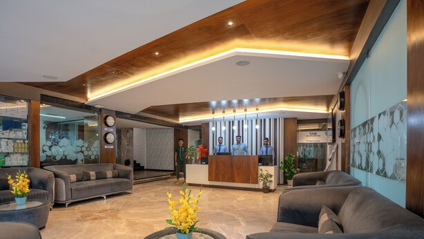 Una moderna zona de recepción con techo de madera, mostrador de recepción y disposición de asientos.