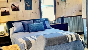 Une chambre à coucher comprenant un lit, des tables de chevet, une fenêtre et des éléments de décoration murale.