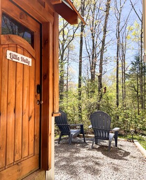 A wooden cabin with a door labeled 'Little Nelly,' two Adirondack chairs, and a gravel patio. - Cloudland Canyon Cozy Private Hideaway (Rising Fawn)