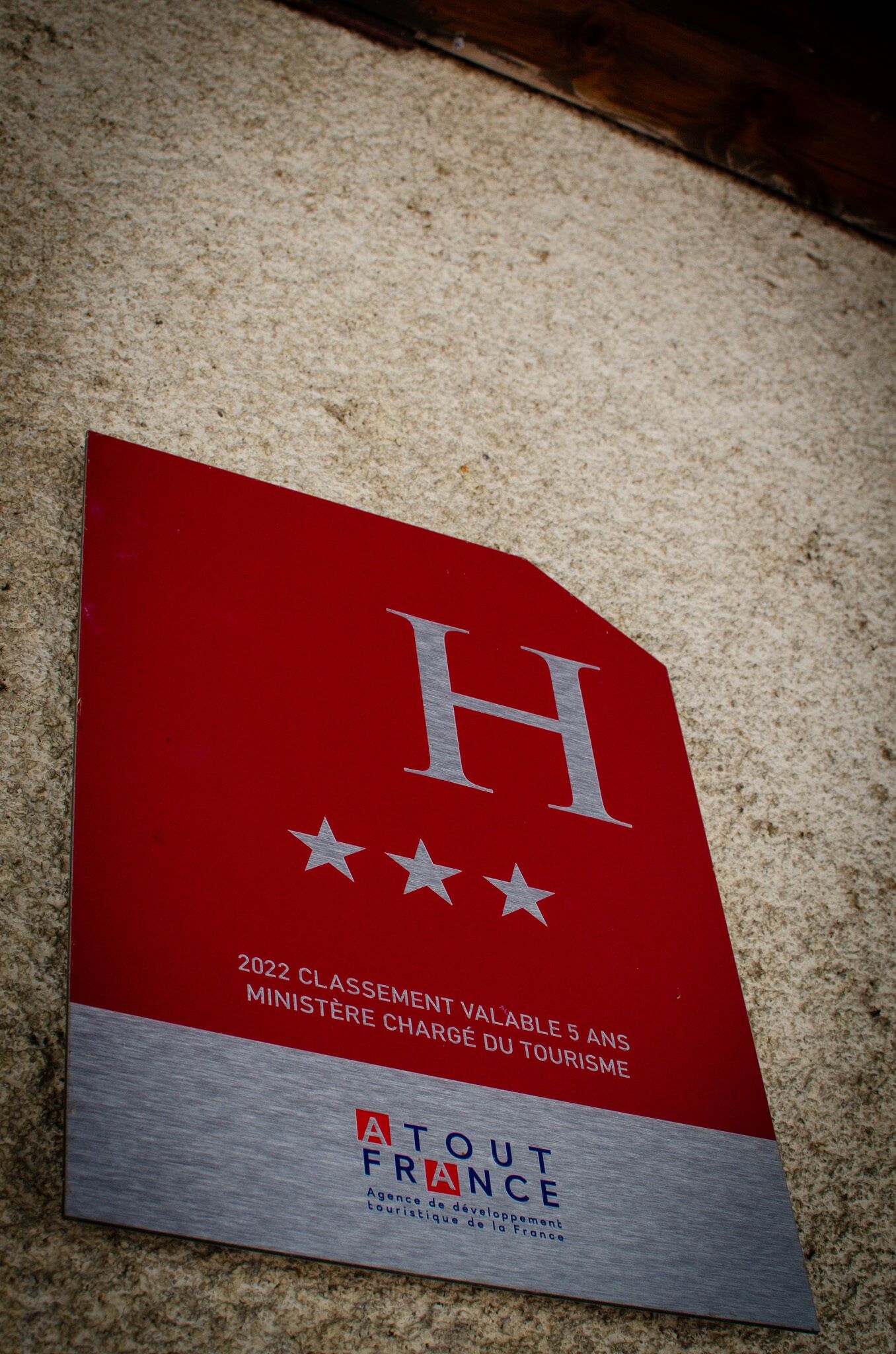 A plaque on a wall with the text "2022 Classement Valable 5 Ans Ministre Charge du Tourisme" and "Atout France".