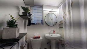 A compact bathroom with a toilet, sink, and a small window. - Stylish Studio, Steps to Transit (Montréal)