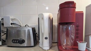A kitchen with a toaster, a coffee maker, and a glass. - Stylish Studio, Steps to Transit (Montréal)