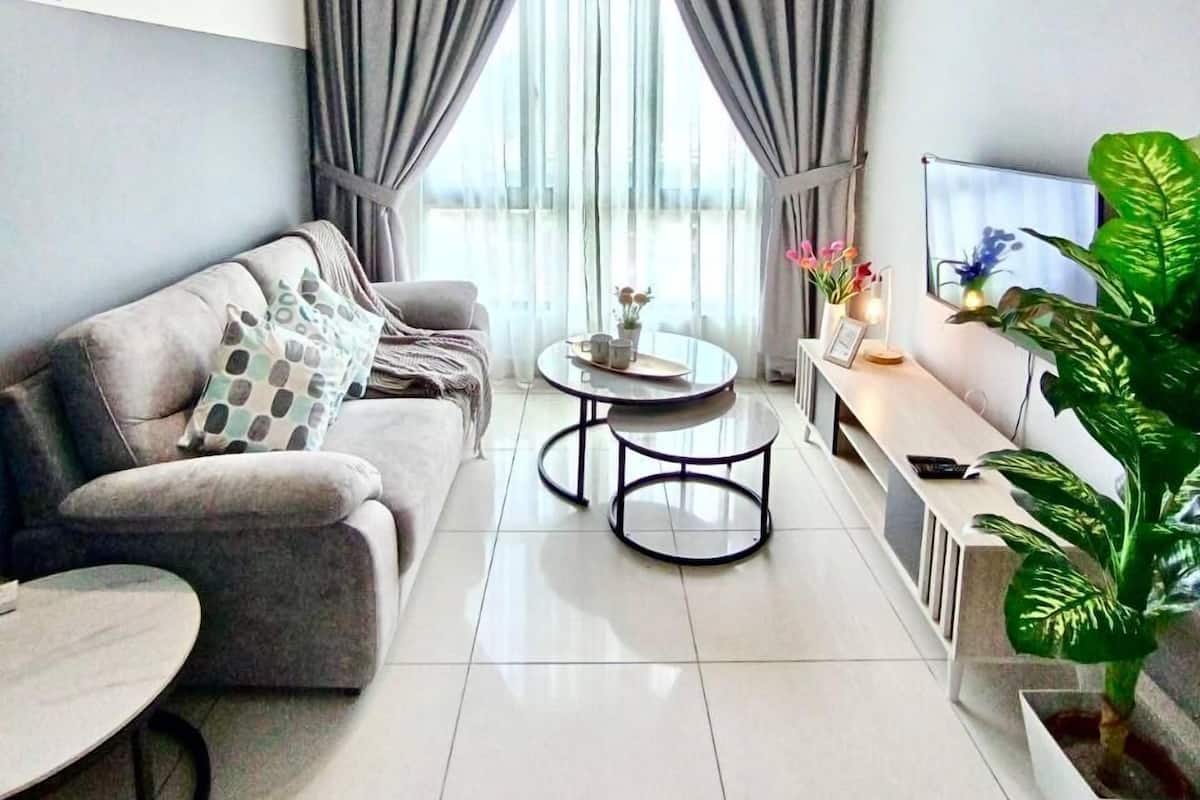 Ein modernes Wohnzimmer mit einer Couch, einem Couchtisch, einem Fernseher und einem Deckenventilator.
