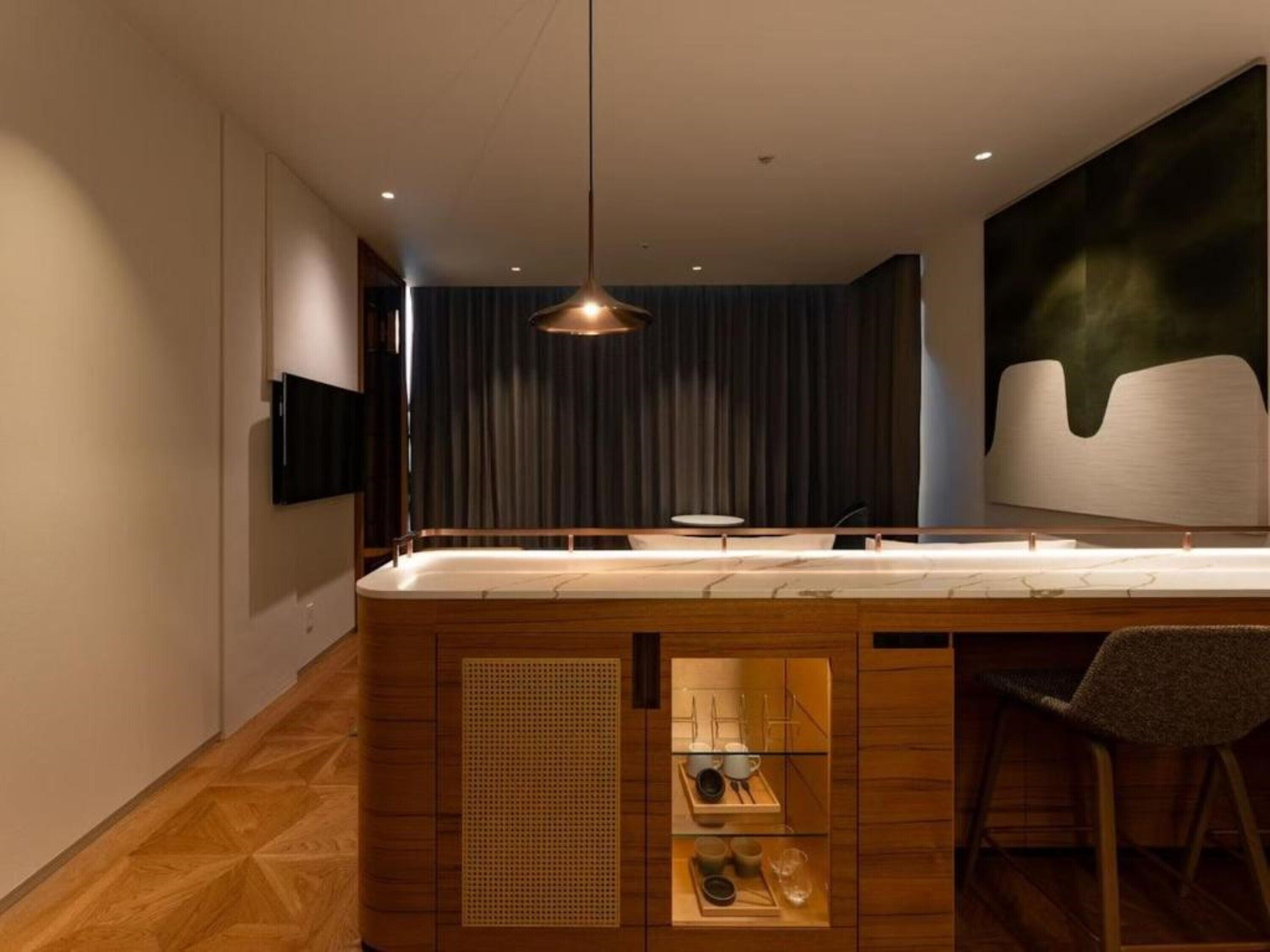 A modern kitchen with a wooden island, a built-in sink, and a pendant light.