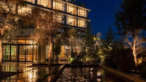 Un edificio moderno con amplios ventanales y una piscina reflectante.