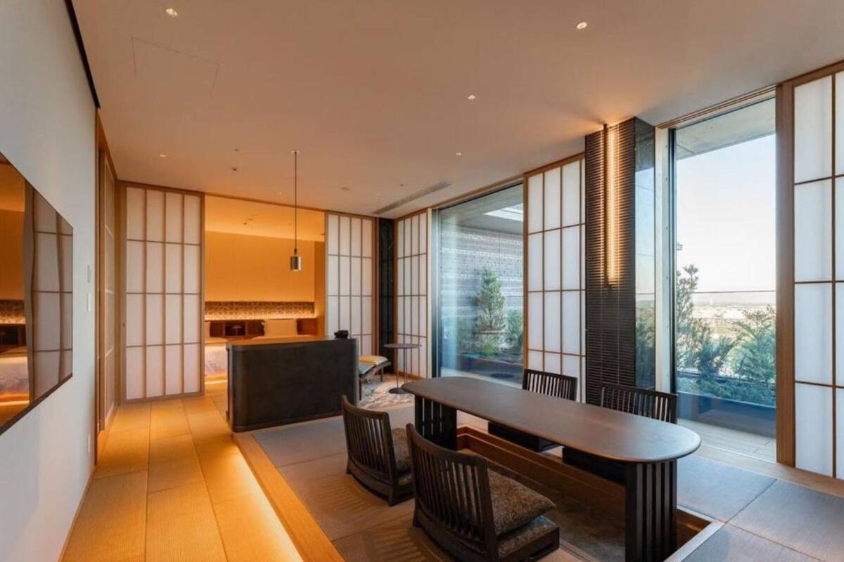 A modern interior with a dining area, large windows, and traditional sliding doors.