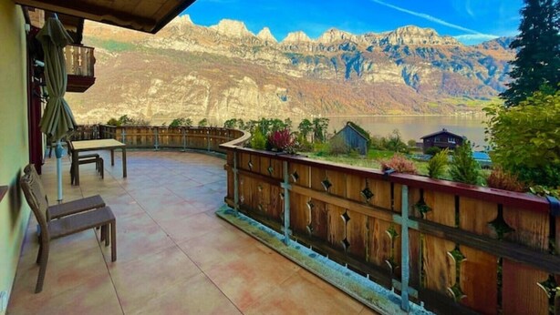 A covered patio with a view of mountains and a lake. - Cozy Accomodation Retreat (Quarten)