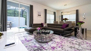 Una sala de estar moderna con un sofá modular, una mesa de centro y una mesa de comedor con superficie de vidrio.