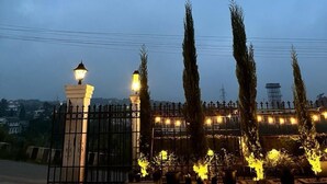 Uma entrada fechada com um poste de luz e uma cerca de metal.