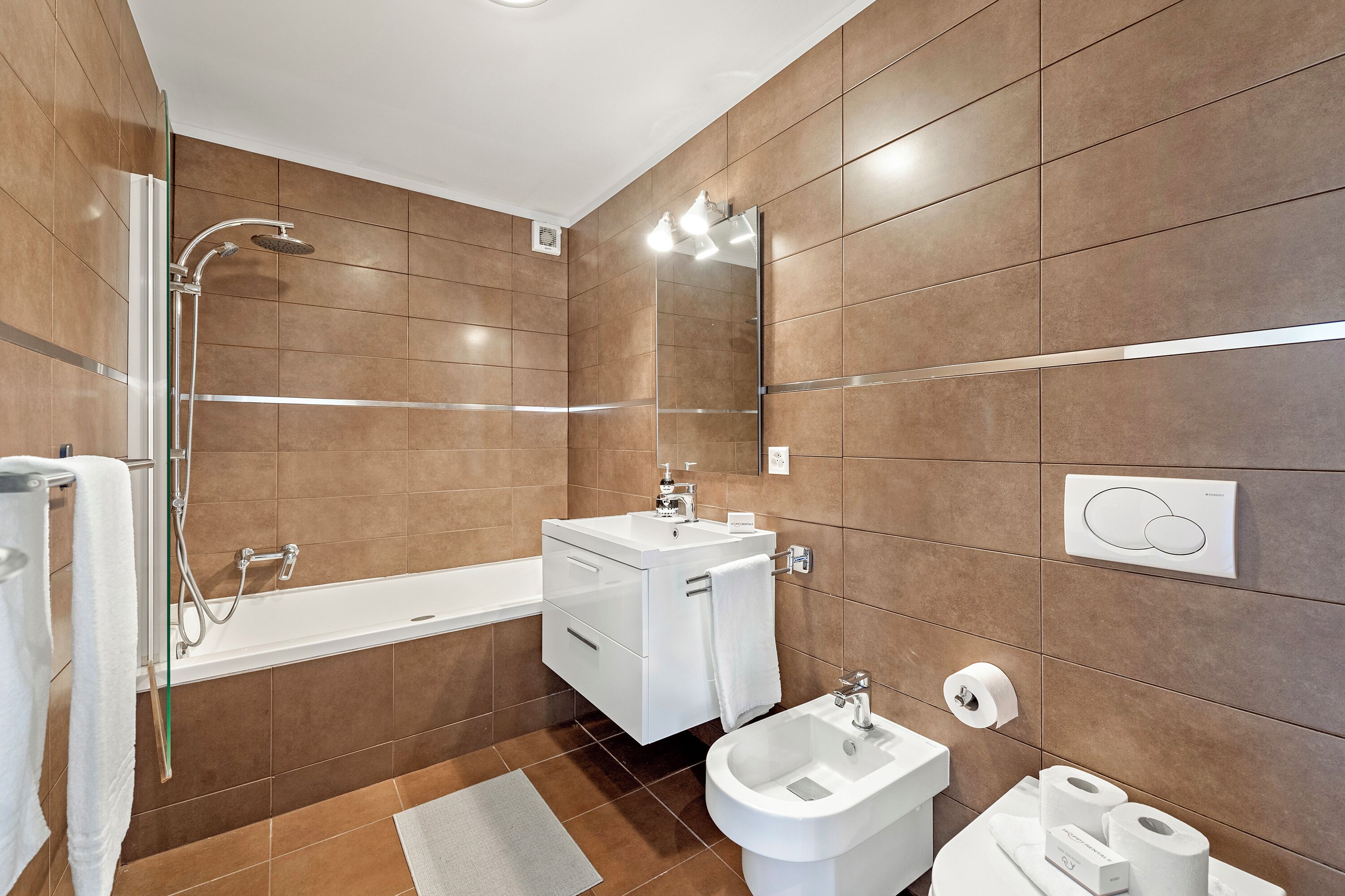 Une salle de bain moderne équipée d’une baignoire, d’une douche, d’un bidet et de toilettes.