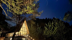 A modern building with a glass facade, surrounded by trees and a body of water. - kobe city shizennoie - Hostel (Kobe)
