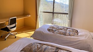 A hotel room with a bed, a desk, and a chair. - kobe city shizennoie - Hostel (Kobe)